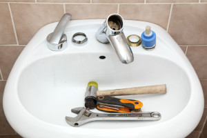 Water tap ceramic cartridge valve and plumber tools in a bathroom